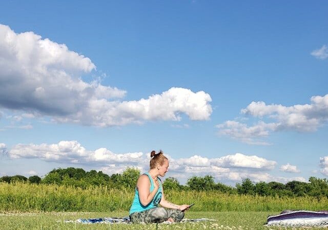 Woman Doing Yoga In Park On Mat